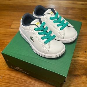 White baby Lacoste sneakers with green laces